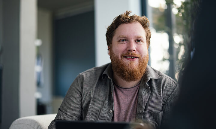 A man smiling to a person off-camera