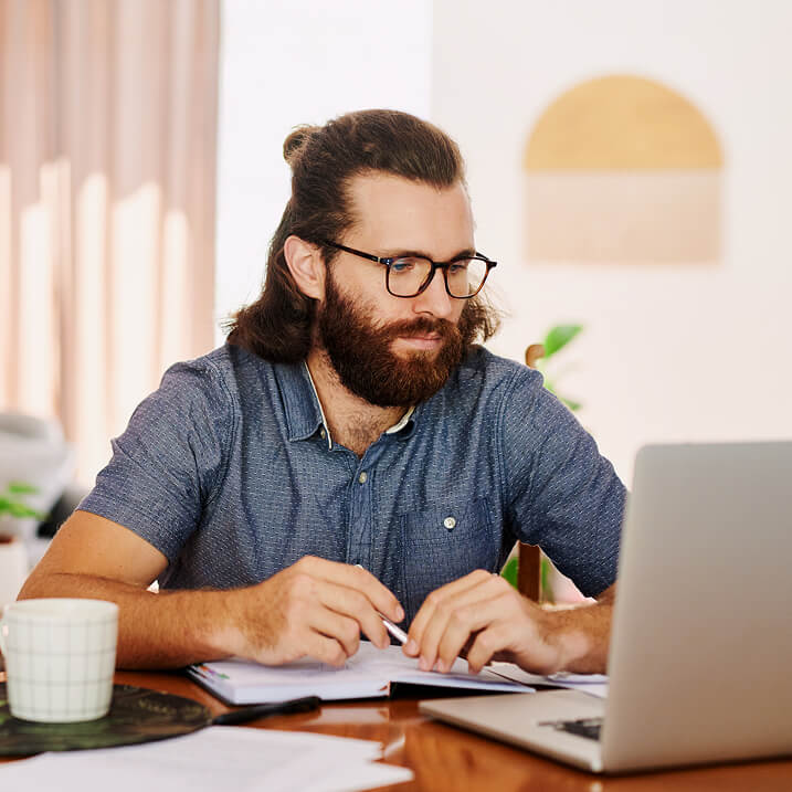 Photo of a man working on his laptop