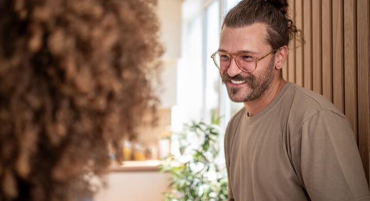 A man smiling at a woman who is faced away from camera